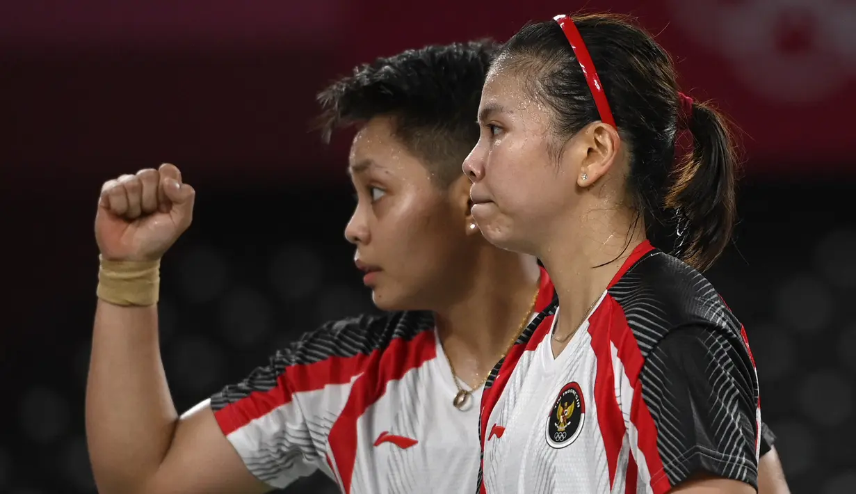 Reaksi ganda putri Indonesia Apriyani Rahayu (kanan) dan Greysia Polii usai menang atas pasangan nomor satu dunia asal Jepang Yuki Fukushima dan Sayaka Hirota pada penyisihan Grup A cabang bulu tangkis Olimpiade Tokyo 2020 di Musashino Forest Sports Plaza, Selasa (27/7/2021). (Alexander NEMENOV/AFP)