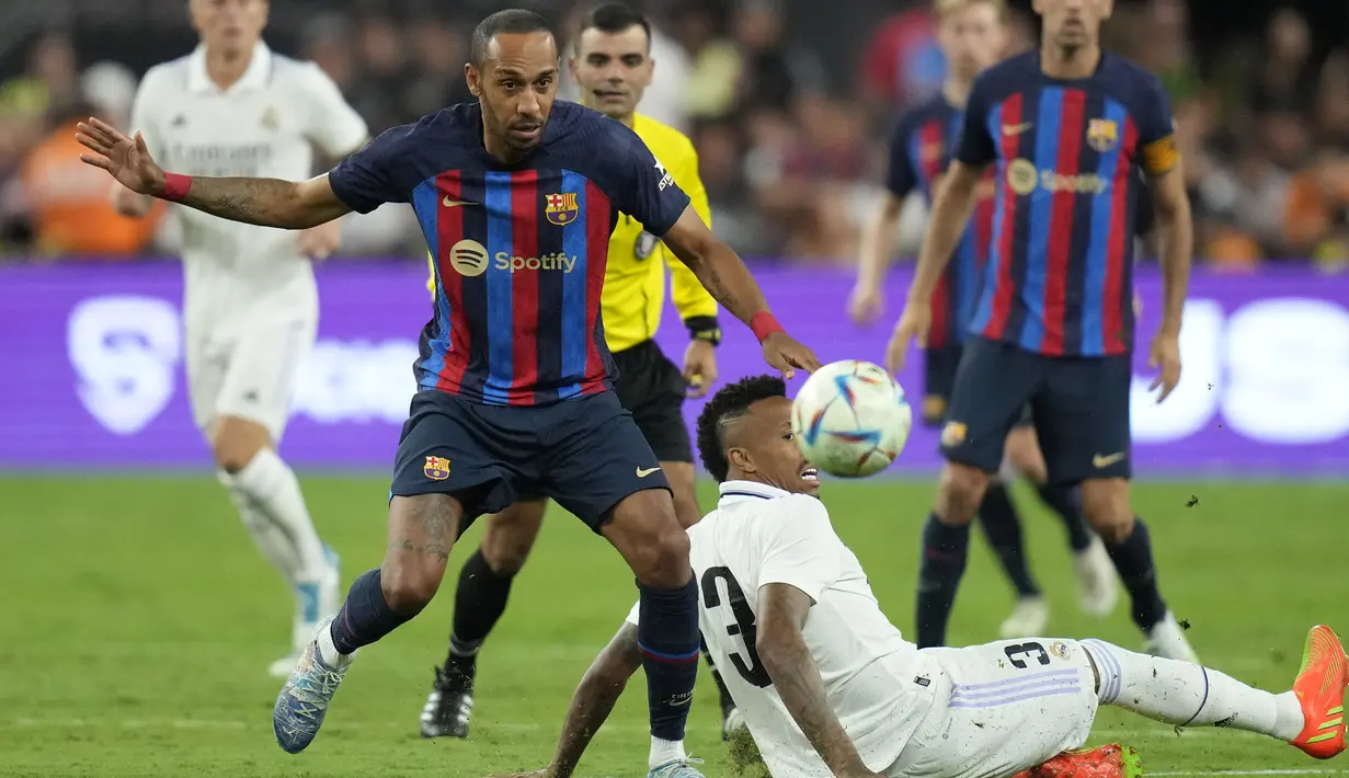 Pemain Barcelona, Pierre-Emerick Aubameyang (kiri) berusaha melewati pemain Real Madrid, Eder Militao saat pertandingan persahabatan antara Real Madrid melawan Barcelona di Stadion Allegiant, Las Vegas, Amerika Serikat, Minggu (24/07/2022) pagi WIB. (AP/John Locher)