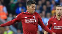 Penyerang Liverpool, Roberto Firmino berusaha menendang bola dari kawalan pemain Brighton and Hove Albion, Yves Bissouma saat bertanding pada lanjutan Liga Inggris di Anfield Stadium (25/8). Liverpool menang atas Brighton 1-0. (AFP Photo/Lindsey Parnaby)