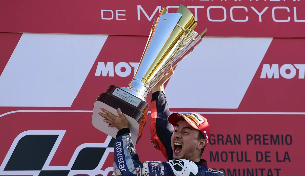 Ekspresi Jorge Lorenzo dengan trofi juara MotoGP Valencia di Sirkuit Ricardo Tormo, Valencia, Spanyol, Minggu (8/11/2015). (AFP Photo/Javier Soriano)