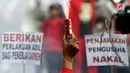 Buruh menyalakan bom asap saat menutup aksi Hari Buruh Internasional di Jalan Medan Merdeka Barat, Jakarta, Rabu (5/1/2019). Buruh dari berbagai organisasi merayakan Hari Buruh Internasional di Kawasan Silang Barat Daya Monas. (Liputan6.com/Helmi Fithriansyah)