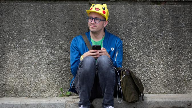 Ekspresi pria asal Los Angeles saat duduk menepi dalam Festival Pokemon Go, di Giant Park, Chicago, Sabtu (22/7). Diperkirakan terdapat 20.000 peserta yang hadir dalam peluncuran produk terbaru dari Pokemon Go. (AP/Erin Hooley)