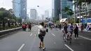Warga menghindari hembusan angin kencang di sekitar Bundaran Hotel Indonesia, Jakarta, Minggu (26/11). Angin kencang dan gerimis terjadi saat kegiatan Hari Bebas Kendaraan, Minggu pagi. (Liputan6.com/Helmi Fithriansyah)