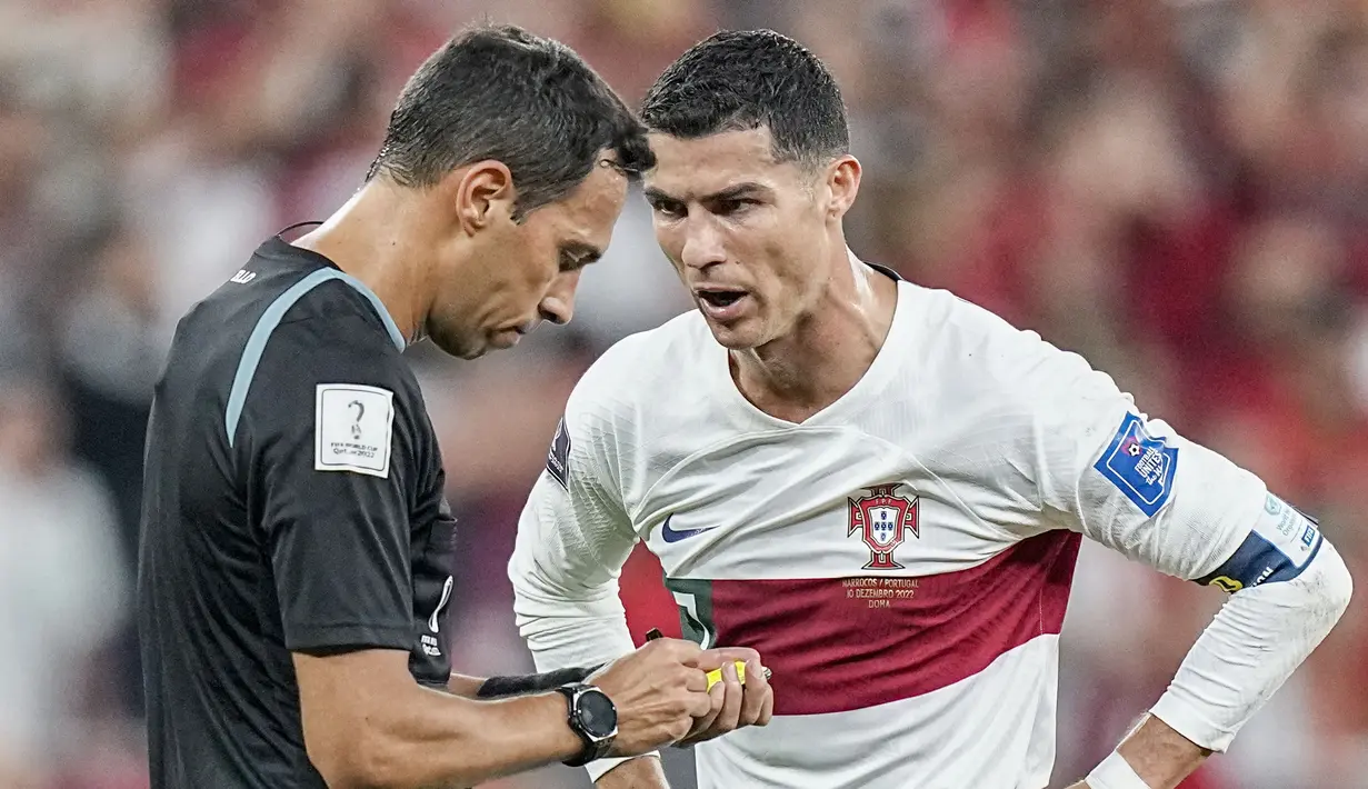 Megabintang Portugal, Crsitiano Ronaldo, berbincang dengan wasit Facundo Tello saat melawan Maroko pada laga babak perempat final Piala Dunia 2022 di Al Thumama Stadium, Sabtu (10/12/2022). (AP/Ariel Schalit)
