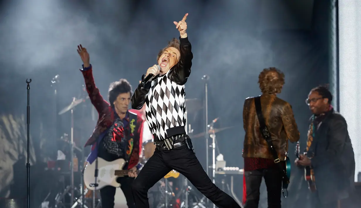 Penampilan Mick Jagger (tengah) saat konser Rolling Stones dalam tur 'No Filter' di Soldier Field, Chicago, Amerika Serikat, Jumat (21/6/2019). Jagger tampil memukau dengan aksinya yang energik di atas panggung. (Kamil Krzaczynski/AFP)
