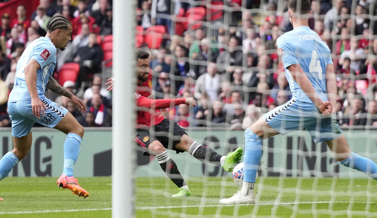 Kapten tim Manchester United, Bruno Fernandes (tengah) melepaskan tendangan yang berbuah gol ketiga timnya ke gawang Coventry City pada laga semifinal Piala FA 2023/2024 di Wembley Stadium, London, Minggu (21/4/2024). (AP Photo/Alastair Grant)