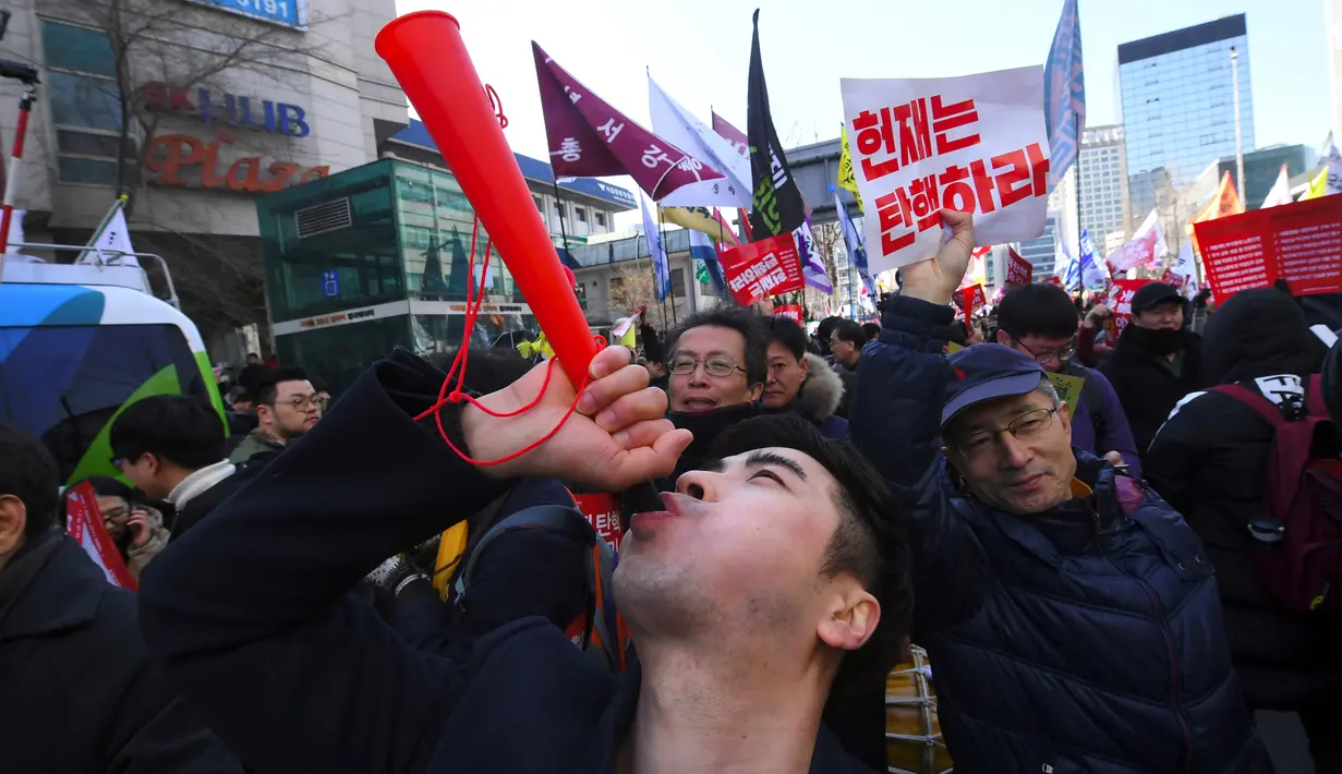 Aktivis anti-pemerintah merayakan pemakzulan Presiden Korea Selatan Park Geun-hye oleh Mahkamah Konstitusi di Seoul, Jumat (10/3). Putusan ini menjadikan Park pemimpin yang terpilih secara demokratis pertama Korsel yang dimakzulkan. (JUNG Yeon-Je/AFP)