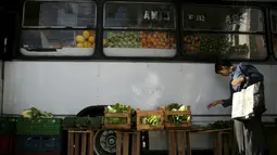 Seorang wanita memilih sayuran saat berbelanja di pasar bus 'Sacolao' di Santa Teresa, Rio de Janeiro, Brasil, Selasa (7/7/2015). Pasar bus ini menjual sayur dan buah-buahan dengan harga yang terjangkau. (REUTERS/Pilar Olivares)