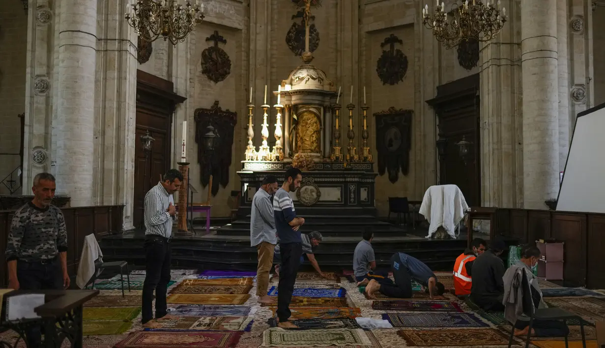 Umat Muslim yang mogok makan berdoa saat mereka menempati gereja Saint-Jean-Baptiste-au-Beguinage di Brussel, Senin (7/6/2021). Puluhan migran tanpa surat resmi dan yang telah menduduki gereja sejak Februari lalu telah memulai mogok makan sejak 23 Mei 2021. (AP Photo/Francisco Seco)