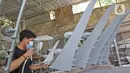 Pekerja menyelesaikan pembuatan miniatur pesawat di workshop Anglo Indonesian Aircraft Models di Cibinong, Kabupaten Bogor, Kamis (15/10/2020). Produk miniatur pesawat buatan Anglo Indonesian Aircraft Models ini telah diekspor ke beberapa negara. (Liputan6.com/Herman Zakharia)