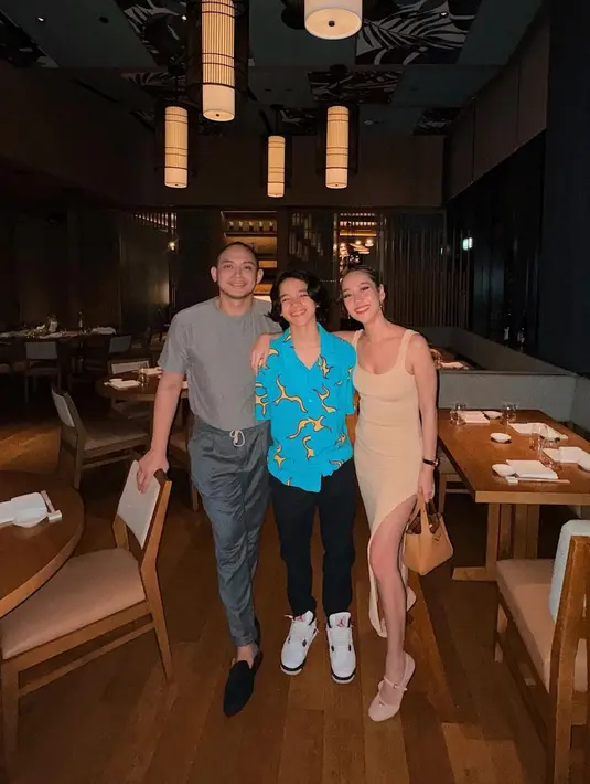 Pasutri Tiko dan BCL jarang terlihat mengenakan outfit yang sama, namun penampilan keduanya selalu tampak serasi. Foto keluarga kecil yang manis, BCL dengan dress bernuansa nudenya, Tiko tampil serba abu-abu, dan Noah dengan summer shirt biru terang. [Foto: Instagram/itsmebcl]