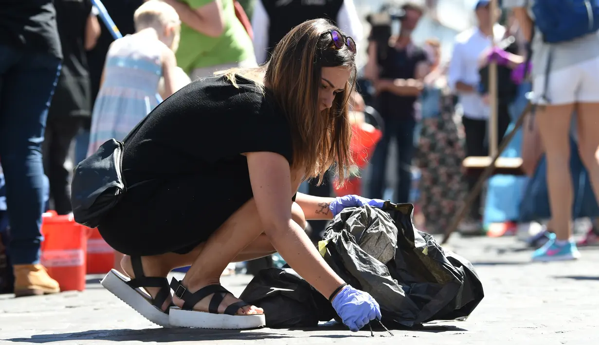 Seorang wanita membersihkan jalanan di sebuah perumahan setelah aksi protes KTT G20 di Hamburg, Jerman, Minggu (9/7). Demonstrasi yang mewarnai gelaran KTT G20 di Hamburg sejak Kamis waktu setempat itu menyebabkan sejumlah kerusakan. (Christof Stache/AFP)