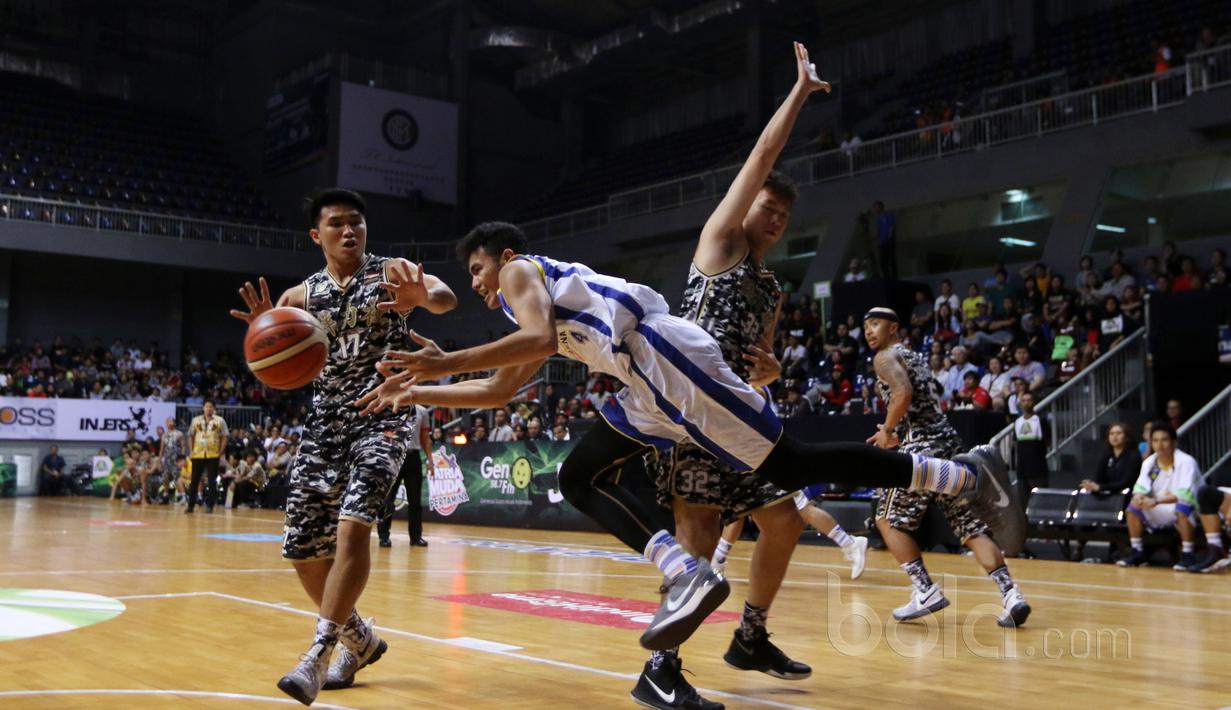 Pemain Satria Muda, Michel (tengah) dikepung dua pemain CLS Knights Surabaya pada laga semifinal IBL di Britama Arena, Kelapa Gading, Jakarta, Minggu (23/4/2017). Satria Muda menang 74-69. (Bola.com/Nicklas Hanoatubun)