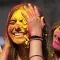 Orang yang bersuka ria mengolesi bedak berwarna di wajah orang lain selama perayaan menandai Holi, festival warna Hindu, di Mumbai, India (18/3/2022).  Holi, festival warna Hindu, juga menandai datangnya musim semi. (AP Photo/Rajanish Kakade)