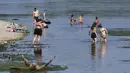 <p>Orang-orang mendinginkan diri di tepi Sungai Ticino, Ponte delle Barche (jembatan perahu), Bereguardo, dekat Milan, Italia, 11 Juli 2023. Gelombang panas yang hebat telah mencapai Italia, membawa suhu mendekati 40 derajat Celcius di banyak kota di seluruh negeri. (AP Photo/Antonio Calanni)</p>