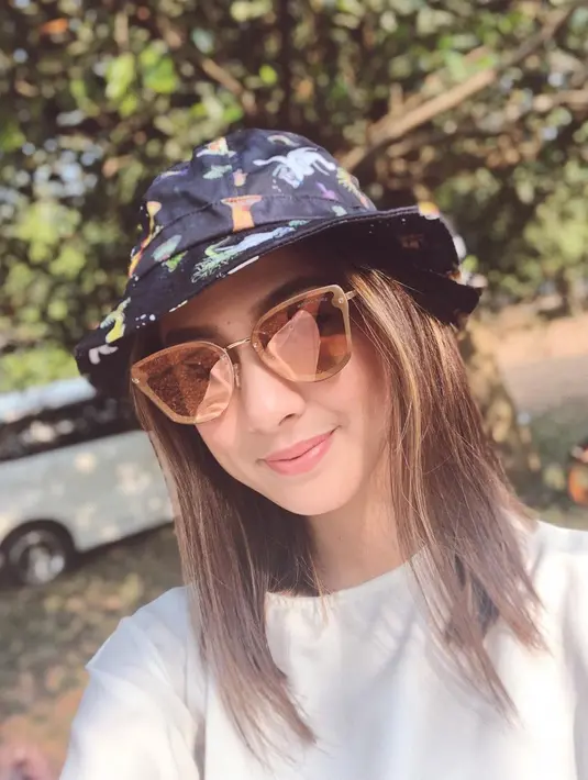 Tak hanya anggun, wanita 24 tahun ini juga tampil trendi dengan memakai kacamata. Seperti kali ini, Nasya Marcella tampak simpel mengenakan kaus putih. Kacamata dan bucket hat yang dipakai membuatnya makin keren.(Liputan6.com/IG/@nasyamarcella)