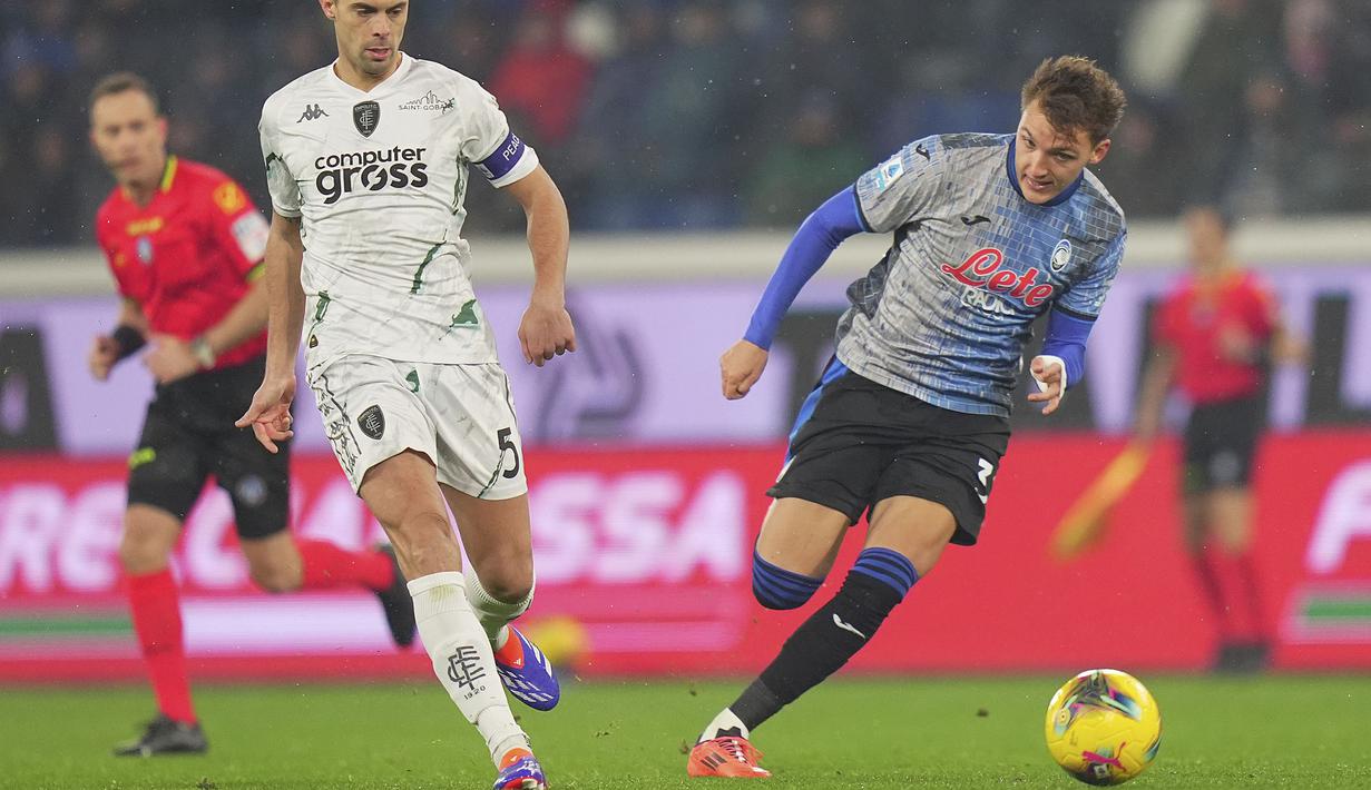 Pemain Atalanta, Mateo Retegui menggiring bola melewati pemain Empoli, Alberto Grassi dalam laga lanjutan Liga Italia 2024/2025 di Gewiss Stadium, Bergamo, Italia, Minggu (22/12/2024) waktu setempat. (AP Photo/LaPresse/Spada)