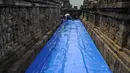 Seorang pekerja melapisi lantai di kompleks candi Borobudur, Magelang, Jawa Tengah, Senin (23/11/2020). Penutupan candi Borobudur oleh BKB (Balai Konservasi Borobudur) sebagai langkah antisipasi melindungi batu candi dari abu vulkanik jika Gunung Merapi erupsi. (Photo by Agung Supriyanto / AFP)