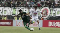 Pemain Persebaya Surabaya, Manu Jalilov, berebut bola dengan pemain Arema FC, Dendi Santoso, dalam leg pertama final Piala Presiden 2019 yang digelar di Stadion Gelora Bung Tomo, Surabaya, Selasa (9/4/2019). Persebaya dan Arema bermain imbang 2-2. (Bola.com/Yoppy Renato)