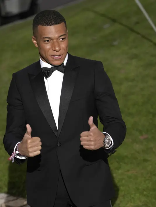 Penyerang PSG, Kylian Mbappe berpose untuk fotografer setibanya menghadiri AmfAR Cinema Against AIDS Benefit selama festival film internasional Cannes ke-75 di Hotel du Cap-Eden-Roc, Cap d'Antibes, Prancis selatan, Kamis (26/5/2022). Mbappe tampil mengenakan jas hitam berdasi kupu-kupu. (AP Photo/Vianney Le Caer)