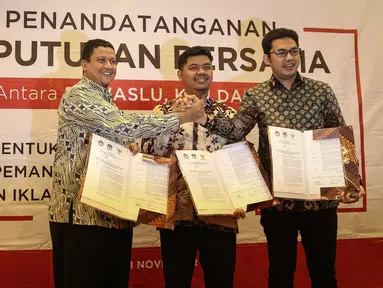 (ki-ka) Ketua Bawaslu Muhammad, Ketua KPU Juri Ardiantoro, Ketua KPI Yuliandre Darwis menunjukan surat usai menandatangani Keputusan Bersama Antara Bawaslu, KPU, Dan KPI di Jakarta, Jumat (11/11). (Liputan6.com/Faizal Fanani)