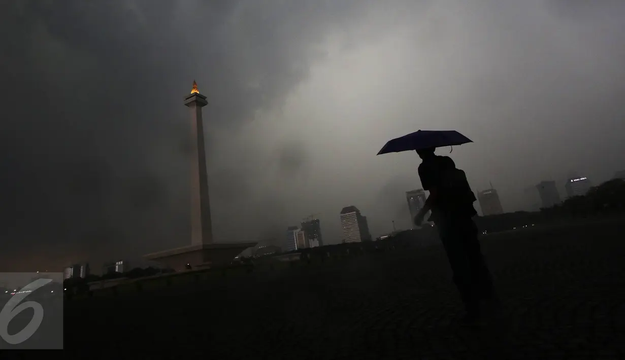 Seorang pegunjung berada di kawasan Monas, Jakarta, Kamis (10/11). Kepala BMKG Andi Eka Sakya menyatakan, cuaca ekstrem yang terjadi di seluruh wilayah Indonesia akan berlangsung hingga Februari 2017. (Liputan6.com/Immanuel Antonius)