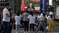 Presiden China Xi Jinping saat berbicara melalui sambungan video dalam sidang Majelis Kesehatan Dunia, tampak di layar raksasa di sebuah jalan di Beijing pada 18 Mei 2020. (AFP)