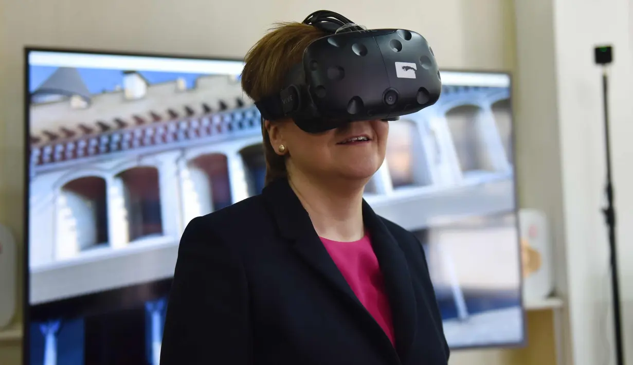 PM Skotlandia Nicola Sturgeon mencoba headset realitas maya selama demonstrasi kemitraan konservasi antara Museum Istana dan Lingkungan Bersejarah Skotlandia, di Kota Terlarang, bekas rumah kaisar Tiongkok, di Beijing (10/4). (AFP Photo/Greg Baker)