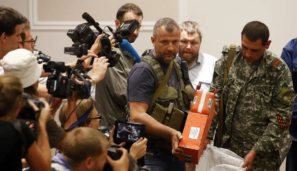 Salah satu anggota kelompok separatis pro-Rusia menunjukkan kotak hitam pesawat Malaysia Airlines MH-17 di Donetsk, (22/7/2014). (REUTERS/Maxim Zmeyev)