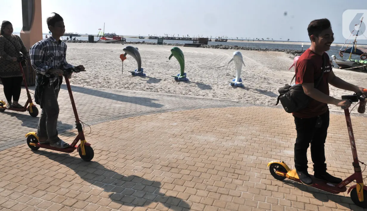 Pengunjung saat berkeliling menggunakan skuter listrik di Pantai Lagoon, Ancol, Jakarta, Rabu (9/10/2019). Pengelola Ancol kini menyediakan penyewaan skuter listrik berbasis aplikasi untuk pengunjung berkeliling kawasan pantai dengan tarif Rp.20.000 per 30 menit. (merdeka.com/Iqbal S. Nugroho)