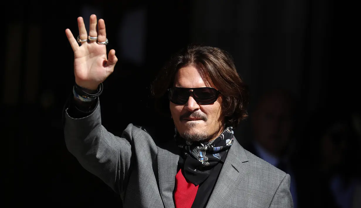 Aktor Johnny Depp memakai kacamata hitam dan syal saat menghadiri sidang pencemaran nama baik di Pengadilan Tinggi, London, Inggris, Selasa (21/7/2020). Johnny Depp menggugat tabloid The Sun atas artikel yang menyebut dirinya telah melakukan kekerasan terhadap sang istri. (AP Photo/Frank Augstein)
