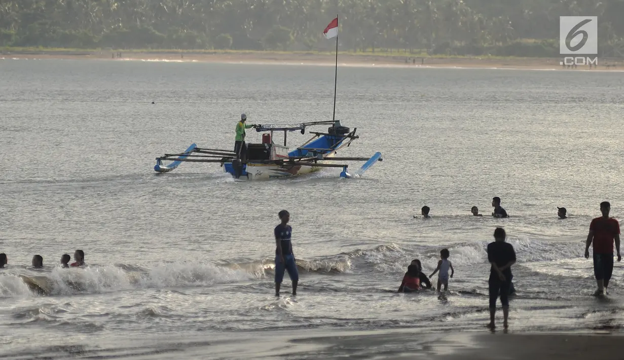 Aktivitas wisatawan di bibir Pantai Palangpang, Kecamatan Ciemas, Sukabumi, Selasa (26/6). Di pantai ini wisatawan juga bisa menyaksikan pemandangan bukit dengan bebatuan purbanya yang megah serta pesona curug dari kejauhan. (Merdeka.com/Arie Basuki)