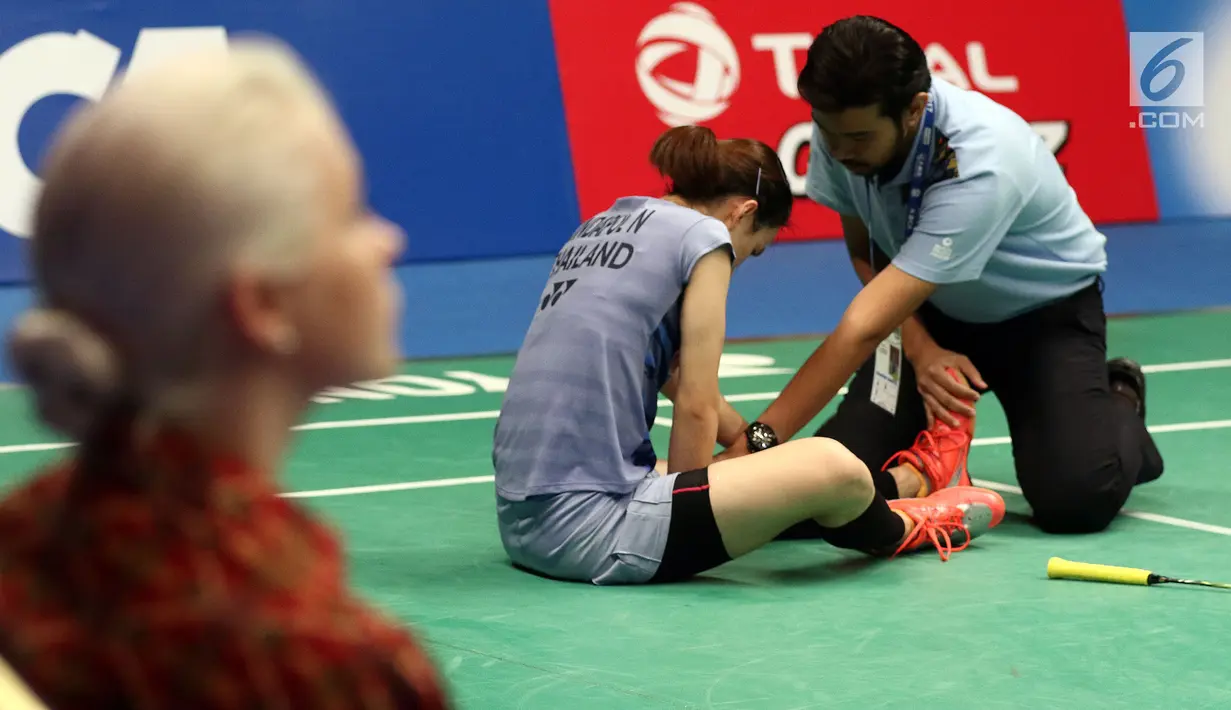 Pebulu tangkis Thailand, Nitchaon Jindapol mendapat pengobatan akibat cedera saat melawan pemain Jepang Sayaka Sato di Semifinal Indonesia Open 2017 di Jakarta, Sabtu (17/6). Jindapol kalah 21-13, 18-21, 14-21. (Liputan6.com/Helmi Fithriansyah)