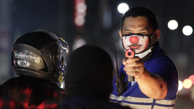 Petugas desa memeriksa suhu tubuh warga di pos pemeriksaan virus corona COVID-19 di Manila, Filipina, Senin (16/3/2020). Polisi beserta petugas lalu lintas dan petugas desa melakukan pengecekan suhu tubuh warga untuk mencegah penyebaran virus corona COVID-19. (AP Photo/Aaron Favila)