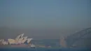 Asap dari kebakaran hutan menyelimuti Sydney di Australia, Selasa (19/11/2019). Sydney diselimuti kabut asap saat kebakaran hutan di timur Australia menyebabkan tingkat polusi di kota terbesar Australia itu naik tajam. (Photo by PETER PARKS / AFP)