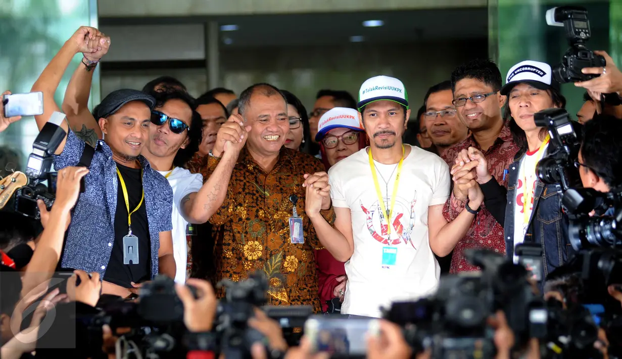 Personel grup band Slank bergandengan tangan dengan Ketua KPK Agus Rahardjo sebelum menggelar konser di halaman Gedung KPK, Jakarta, Senin (22/2). Dalam aksinya, Slank memberikan dukungan kepada KPK menolak rencana revisi UU. (Liputan6.com/Helmi Afandi)