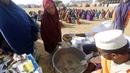 LSM lokal menyiapkan makanan berbuka puasa untuk orang-orang selaam bulan suci Ramadhan di kamp pengungsi internal di pinggiran Mogadishu, Somalia pada Jumat, 24 Maret 2023. (AP Photo/Farah Abdi Warsameh)