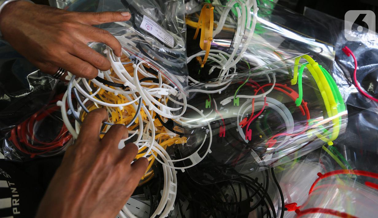 Sukarelawan 3D merapikan face shield atau pelindung wajah di IMA 3D, Cipondoh, Kota Tangerang, Kamis (23/4/2020). Face shield berbahan plastik dan mika telah didonasikan sebanyak 69 ribu oleh sejumlah sukarelawan 3D selama pandemi Covid-19. (Liputan6.com/Fery Pradolo)