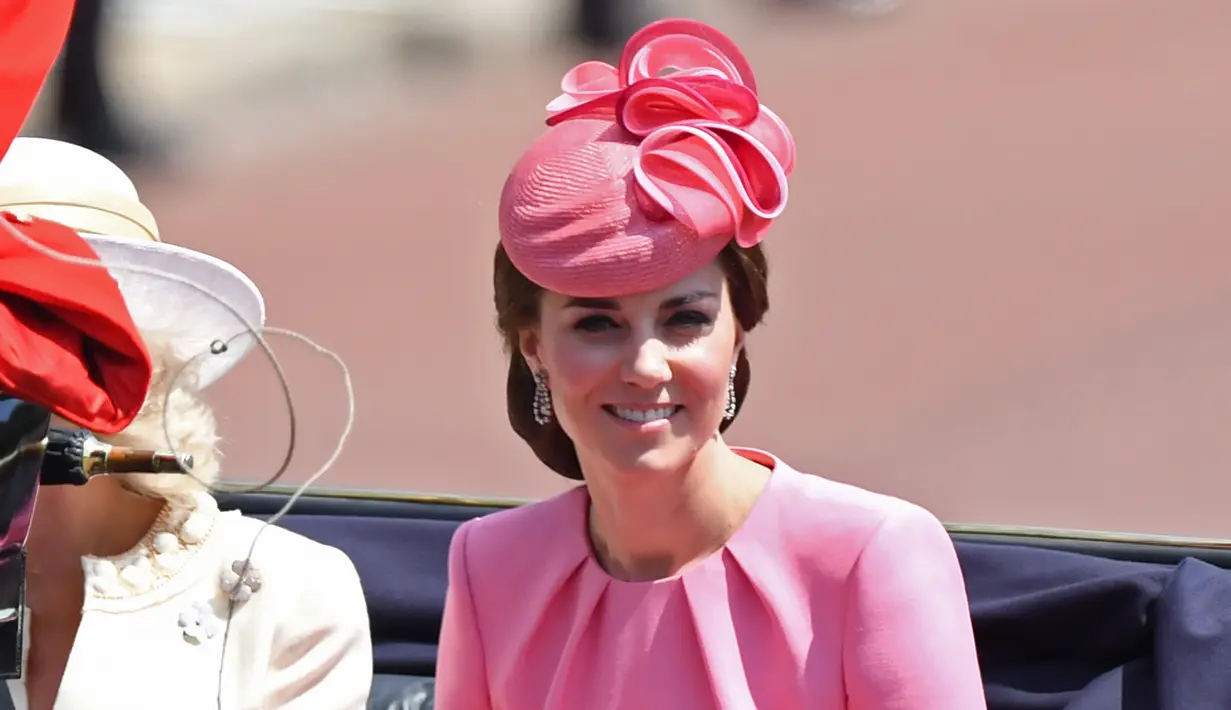 Kate Middleton menaiki kereta kuda saat parade Trooping the Color di London, Inggris, Sabtu (17/6). Untuk parade yang digelar dalam rangka perayaan resmi ulang tahun Ratu Elizabeth itu, Kate Middleton mengenakan busana serba pink. (Chris J Ratcliffe/AFP)