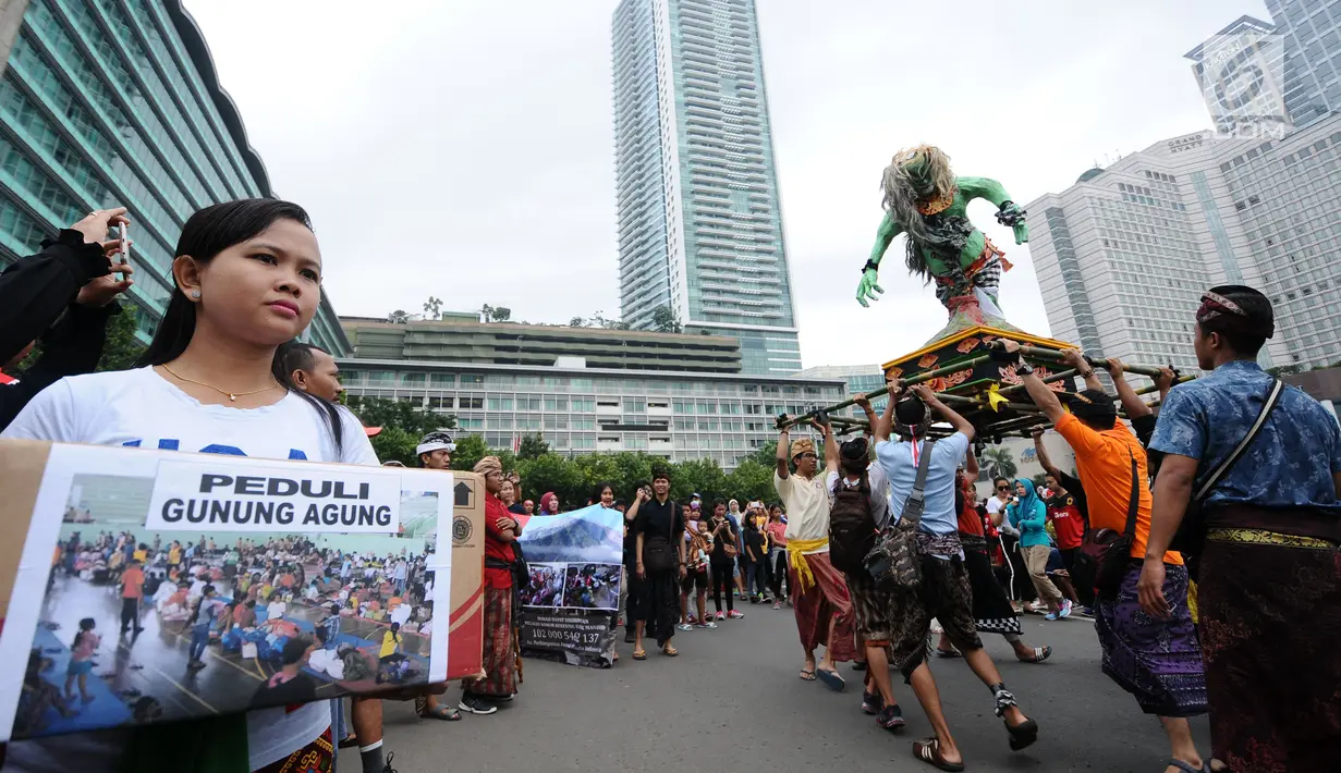 Aktivis Perhimpunan Pemuda Hindu Indonesia melakukan aksi penggalangan dana untuk pengungsi Gunung Agung saat Hari Bebas Kendaraan di Kawasan Bundaran HI Jakarta, Minggu (1/10). (Liputan6.com/Helmi Fithriansyah)