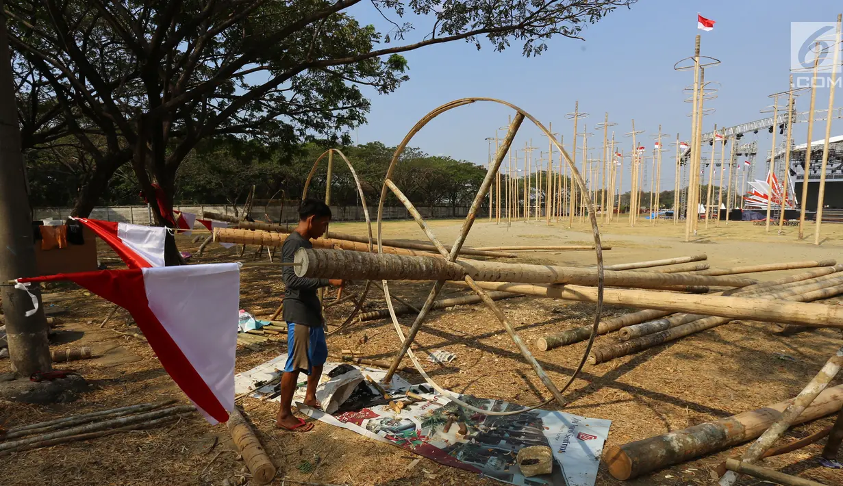 Pekerja memasang bendera Merah Putih pada pohon pinang untuk acara panjat pinang kolosal di kawasan Ancol, Jakarta, Kamis (15/8/2019). Ancol Taman Impian menggelar berbagai acara dalam menyambut HUT ke-74 RI, salah satunya adalah Panjat Pinang Kolosal. (Liputan6.com/Herman Zakharia)