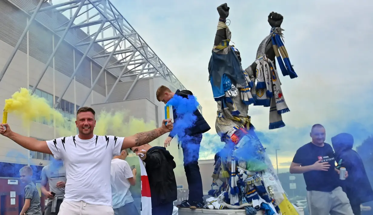 Suporter Leeds United merayakan keberhasilan timnya yang sukses kembali ke kompetisi Premier League di Elland Road, Leeds, Sabtu (18/7/2020). Leeds United dipastikan promosi ke Premier League musim 2020/2021 usai West Brom kalah 1-2 atas Huddersfield Town. (AFP/Paul Ellis)