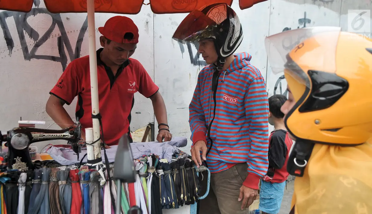 Penjahit keliling mengukur pakaian pelanggan yang akan dijahit ulang, Jakarta, Kamis (22/6). Jelang lebaran, penjahit keliling mulai banyak menerima orderan warga untuk sekedar memotong atau mengecilkan pakaian. (Liputan6.com/Yoppy Renato)