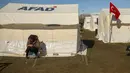 Seorang pria duduk di dekat tenda di kamp tenda di Adiyaman, Turki selatan, Senin, 13 Februari 2023. Banyak dari puluhan ribu penyintas yang kehilangan tempat tinggal masih berjuang untuk memenuhi kebutuhan dasar, seperti mencari tempat berlindung dari hawa dingin yang menggigit. (AP Photo/Emrah Gurel)