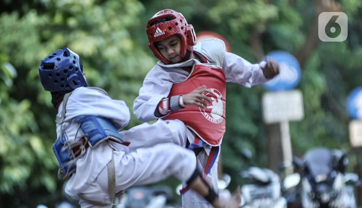 Murid Taekwondo Indonesia Manroe Club mengikuti latihan rutin di kawasan Kanal Banjir Timur (KBT), Jakarta Timur, Senin (16/8/2021). Taekwondo Manroe menggelar latihan di ruang terbuka akibat pemerintah meniadakan sementara olahraga di GOR selama pandemi COVID19. (merdeka.com/Iqbal S. Nugroho)