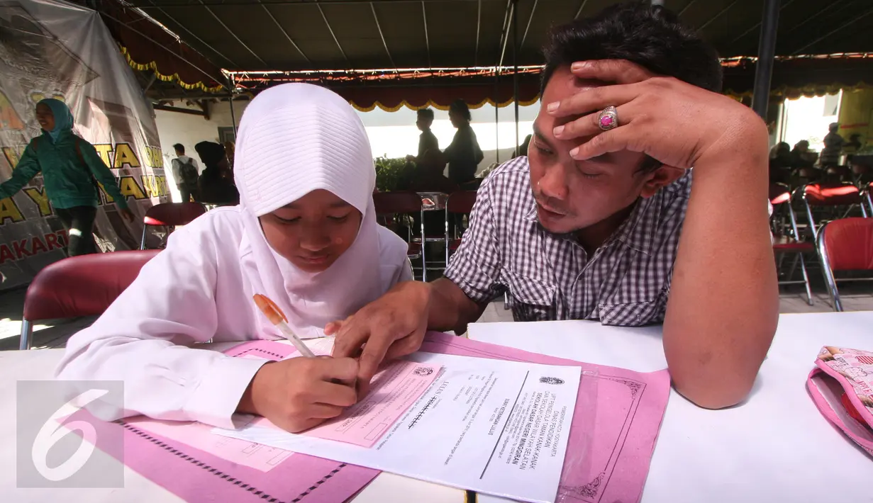 Siswi didampingi orangtuanya mengisi formulir Penerimaan Peserta Didik Baru (PPDB) di Dinas Pendidikan Kota Yogyakarta, Rabu (15/6). PPDB jalur pemegang Kartu Menuju Sehat (KMS) diminati siswa untuk mendapatkan sekolah favorit. (Liputan6.com/Boy Harjanto)