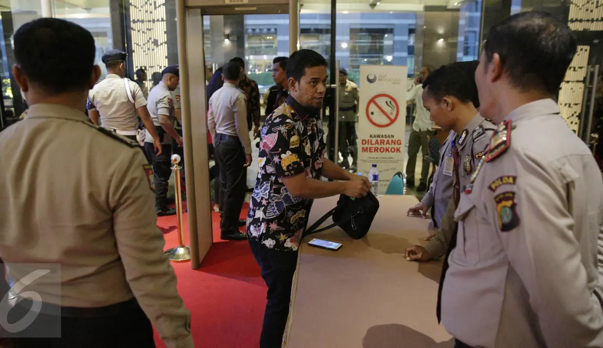 Petugas kepolisian memeriksa pengunjung yang hendak masuk dalam Debat terakhir Pilgub DKI Jakarta 2017, Jakarta, Rabu (12/4). Subtema dari debat tersebut terkait dengan masalah transportasi, tempat tinggal, reklamasi. (Liputan6.com/Faizal Fanani)