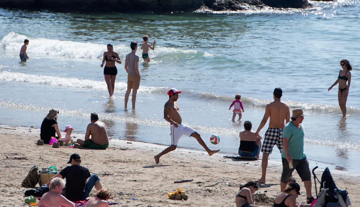 Orang-orang berjemur dan berenang di pantai Catalans (Plage des Catalans) di Marseille, Prancis Selatan, (17/4). Pantai ini memiliki dua lapangan voli pantai di mana beberapa kompetisi internasional diselenggarakan. (AFP Photo/Bertrand Langlois)
