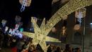 Orang-orang berfoto di bawah lampu-lampu Natal di pusat kota Vigo, barat laut Spanyol, pada 16 November 2024. (MIGUEL RIOPA/AFP)