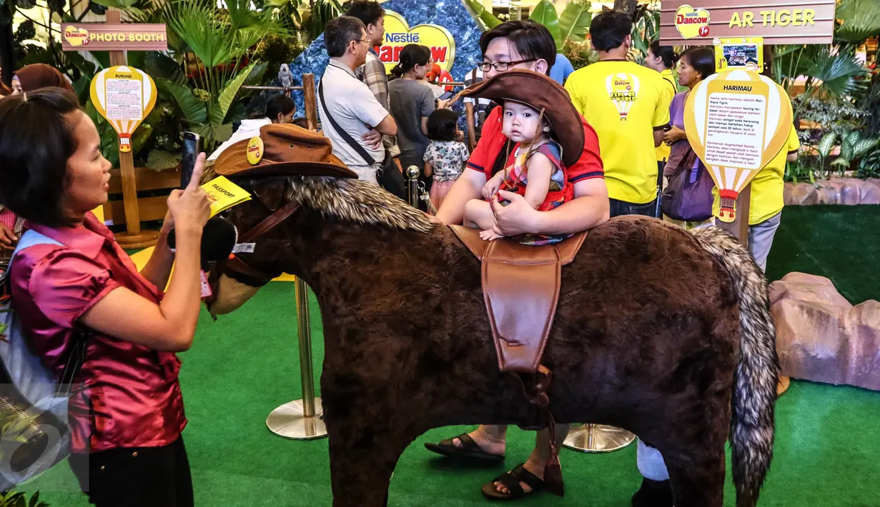 Seorang anak berpose di atas kuda di area bermain dan belajar Mal Taman Anggrek, Jakarta (02/04). Nestle Dancow 1+ menghadirkan kegiatan mengajak si anak-anak menjelajah dunia dan mendorong rasa keinginannya hujannya. (Liputan6.com/Fery Pradolo)